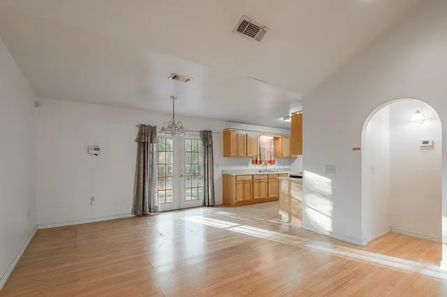 a view of a room with a chandelier and wooden floor