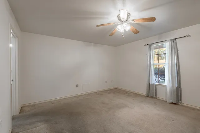 an empty room with chandelier fan