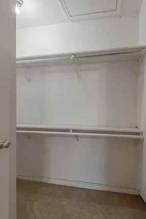 an empty room with windows and chandelier fan