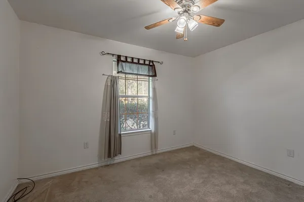 an empty room with a chandelier fan