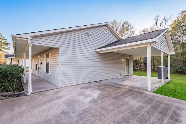 a view of a house with a big yard and large trees