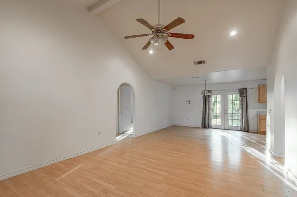 an empty room with wooden floor and windows