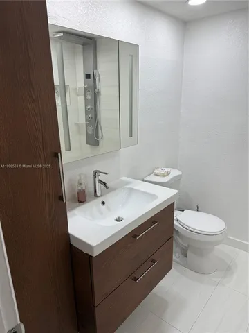 a bathroom with a toilet sink and mirror