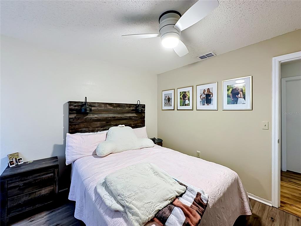 3705 Southwest 27th Street, Unit 922 Gainesville, FL 32608 - Photo 23 of 34 a bedroom with a bed and wooden floor