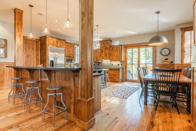 a view of a dining room and livingroom with furniture wooden floor a chandelier