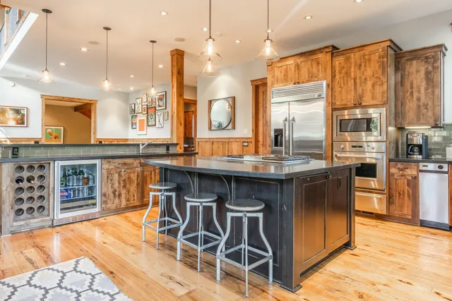 a kitchen with stainless steel appliances granite countertop a stove a sink and a refrigerator