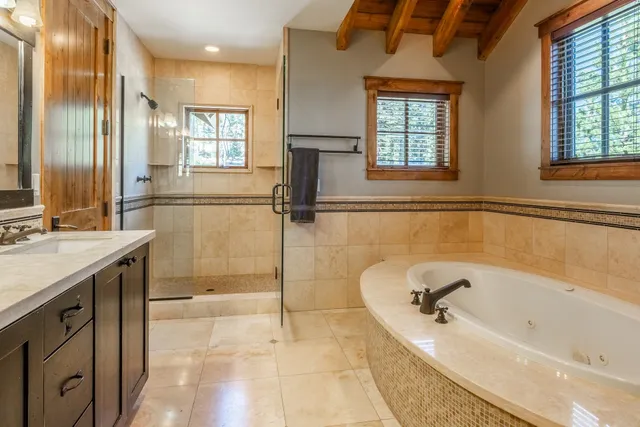 a bathroom with a tub a sink and a shower