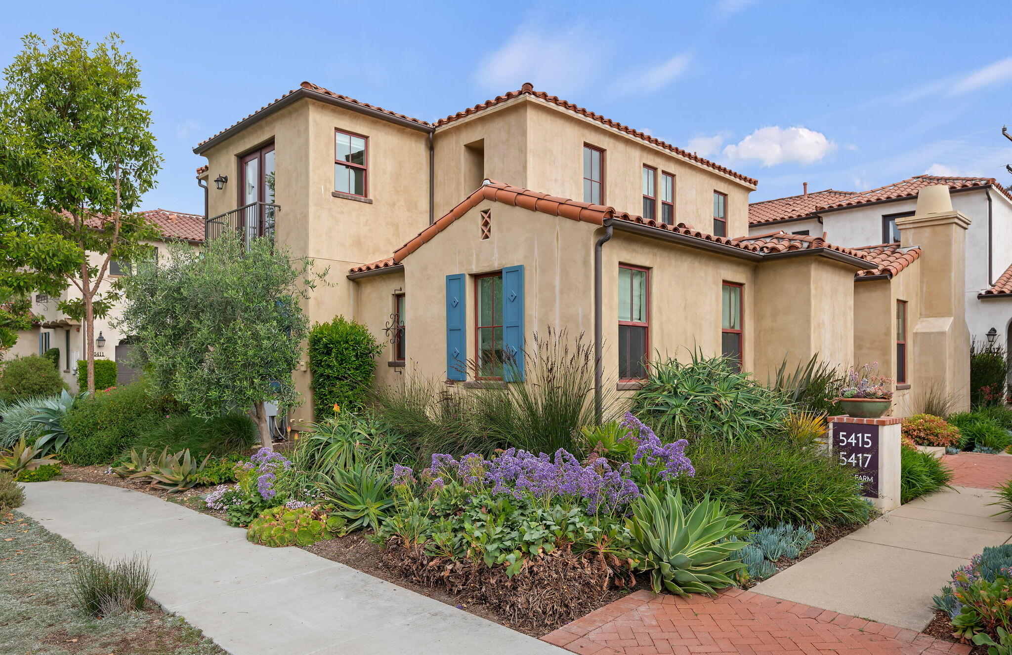 a front view of a house with plants
