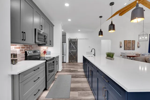 a kitchen with white cabinets and refrigerator