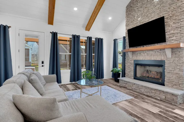 a living room with furniture a fireplace and a flat screen tv