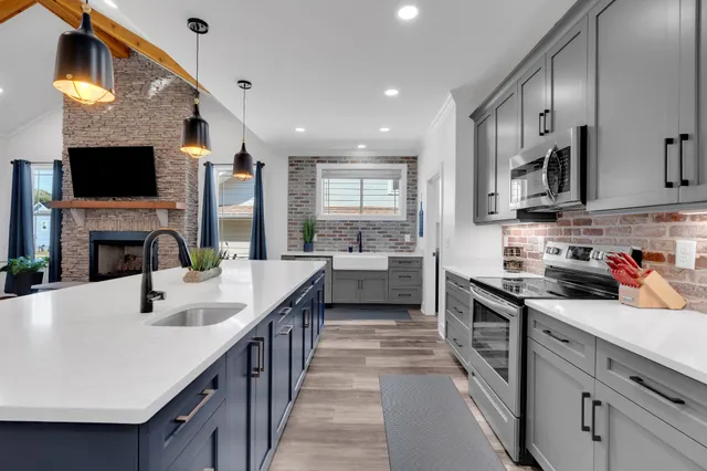 a kitchen with kitchen island granite countertop a sink appliances and cabinets