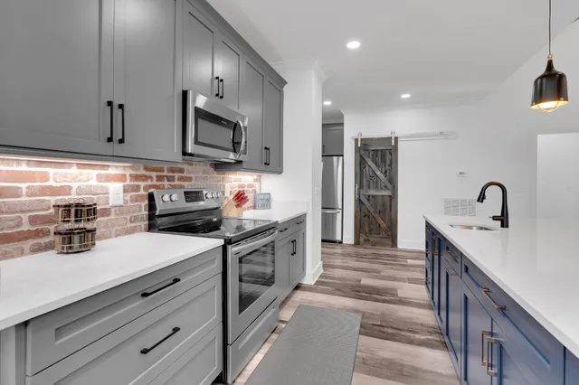 a large kitchen with stainless steel appliances kitchen island granite countertop a sink and cabinets