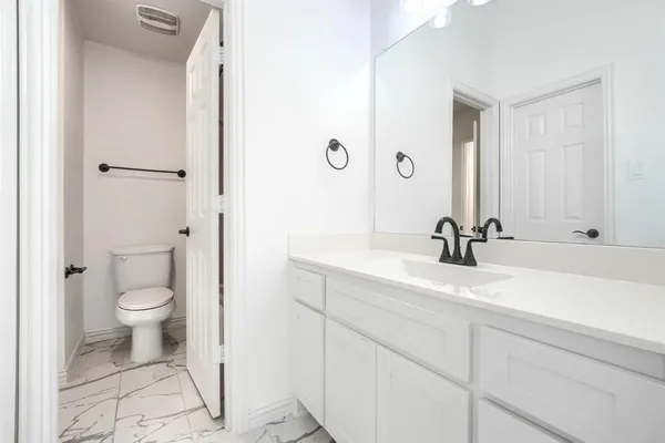 a bathroom with a toilet a sink and mirror