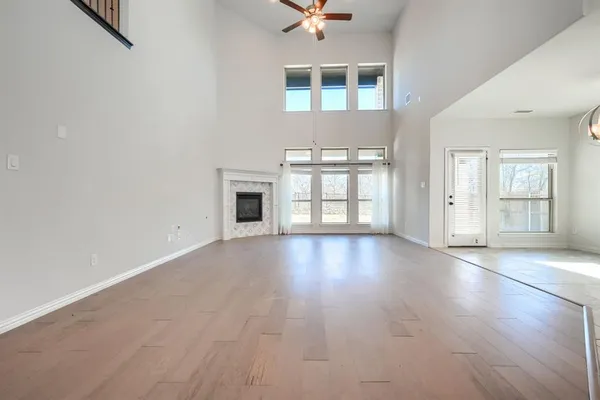 a view of an empty room with window and wooden floor