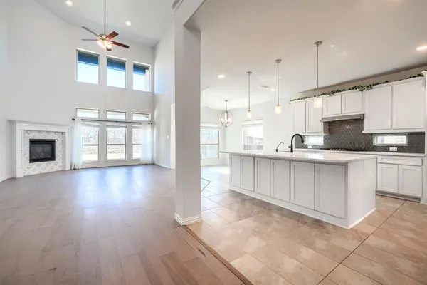 a kitchen with kitchen island granite countertop a stove a sink a refrigerator and a wooden cabinets