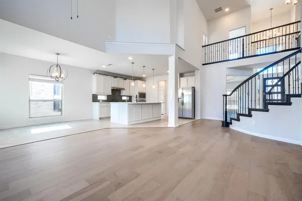 a view of an empty room with stairs and windows