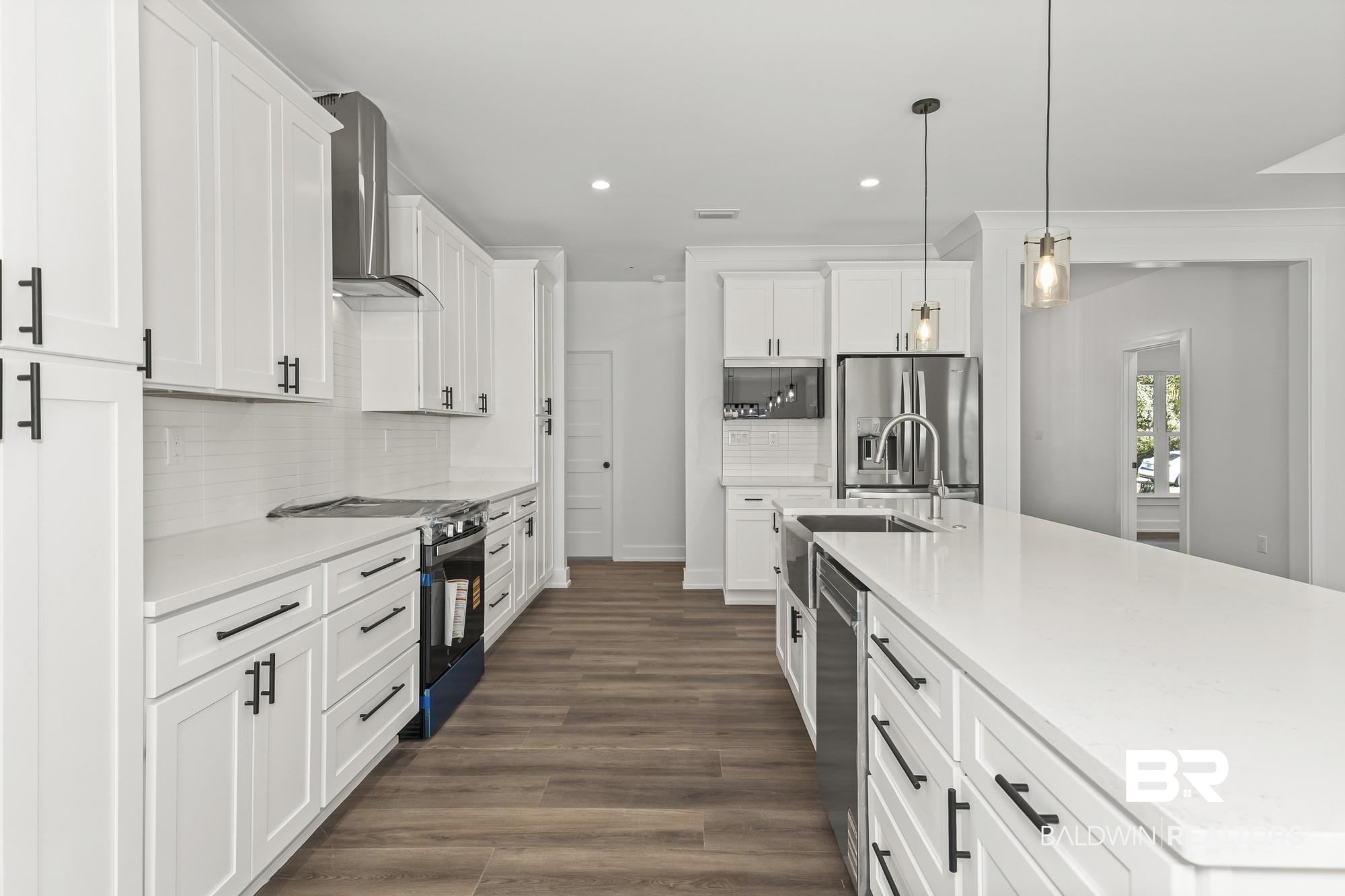 10180 Pineview Drive Foley, AL 36535 - Photo 14 of 47 Kitchen with white cabinetry, pendant lighting, a large island with sink, stainless steel appliances, and light stone countertops