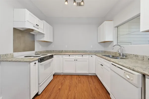 a kitchen with granite countertop white cabinets and white appliances