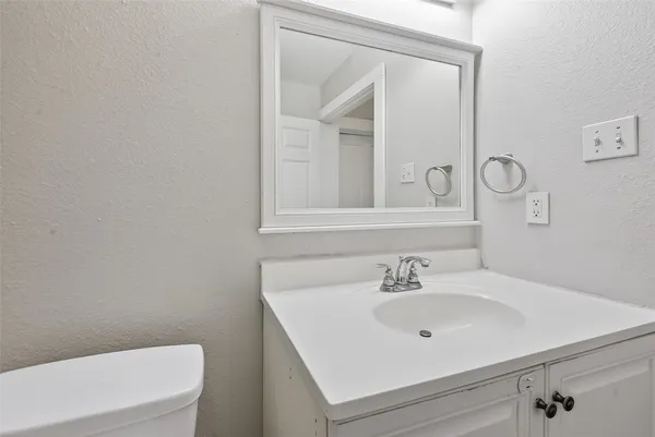 a bathroom with a sink a toilet and mirror