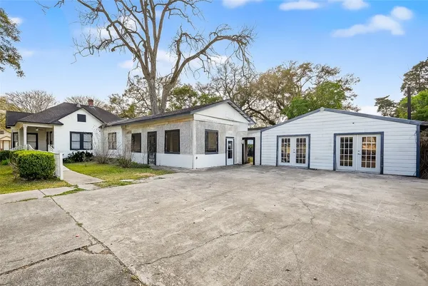 a view of a white house with a yard and potted plants