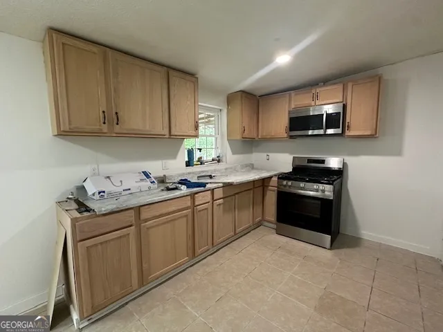 a kitchen with stainless steel appliances granite countertop a sink and a stove top oven