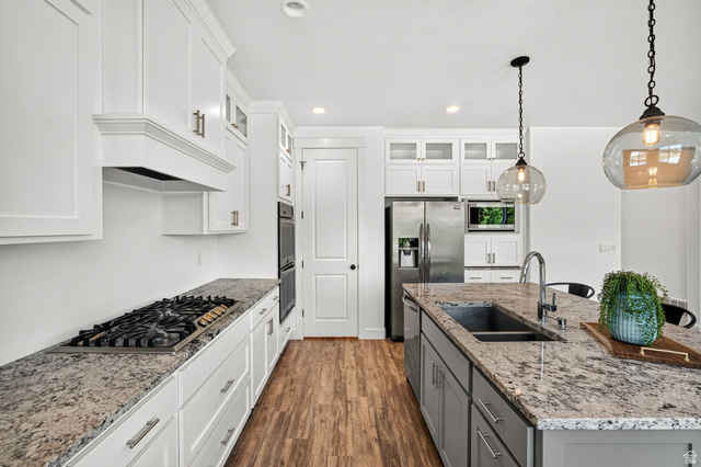 6536 West Muirfield Road Highland, UT 84003 - Photo 7 of 48 Modern kitchen featuring white cabinetry, granite countertops, a gas cooktop, stainless steel appliances, and wood-finish flooring