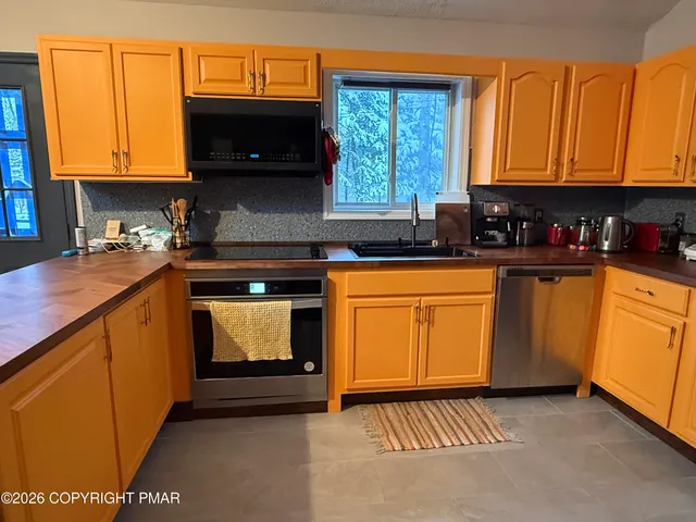 a kitchen with a sink a stove and cabinets