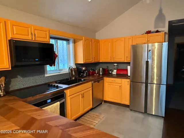 a kitchen with stainless steel appliances granite countertop a refrigerator sink and microwave
