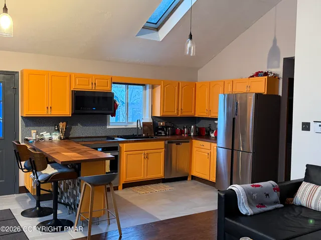 a kitchen with stainless steel appliances granite countertop a refrigerator and a stove top oven
