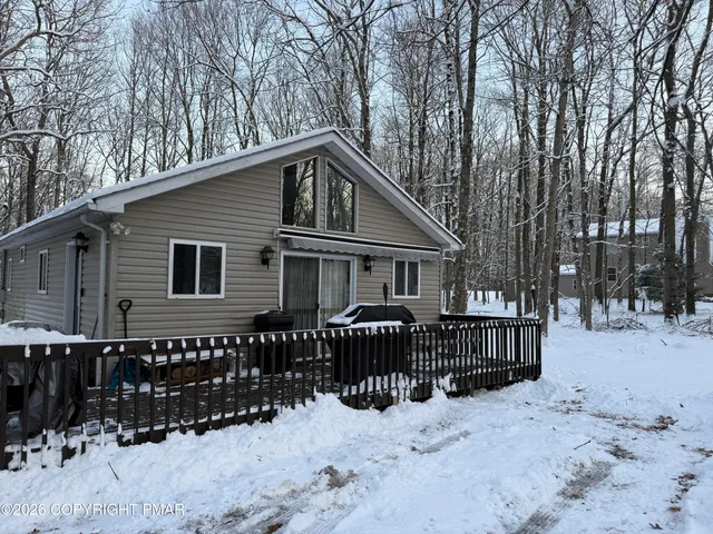 a front view of a house with a yard covered in snow