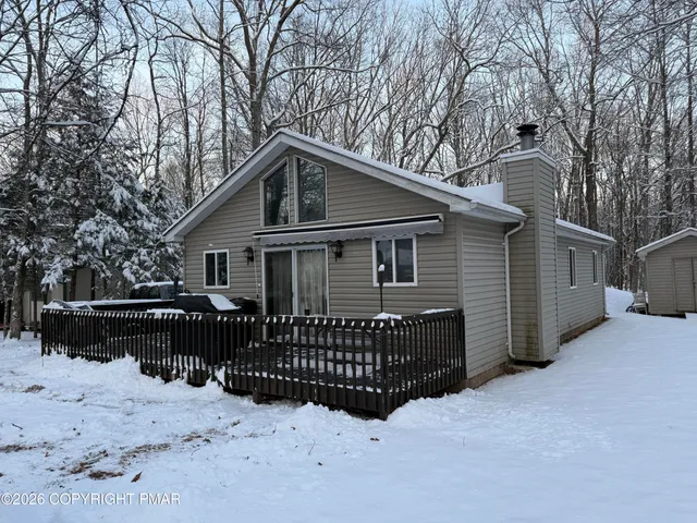 a front view of a house with a yard covered in snow
