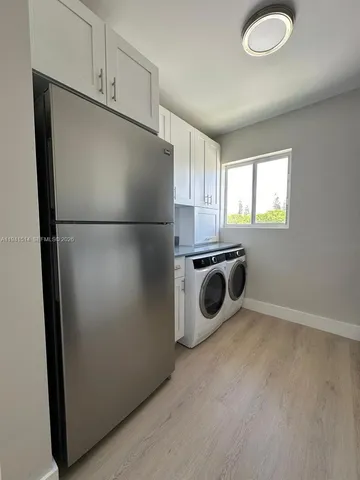 a kitchen with a refrigerator a washer and dryer