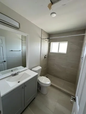 a bathroom with a double vanity sink toilet and shower