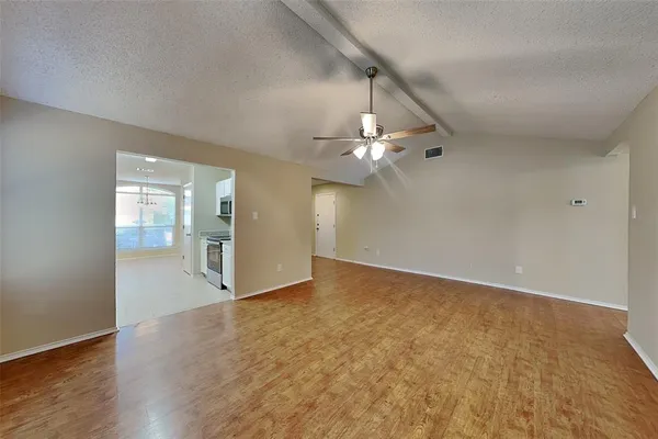 a view of an empty room with wooden floor