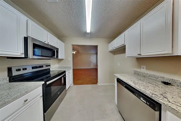 a kitchen with stainless steel appliances granite countertop a sink stove and microwave