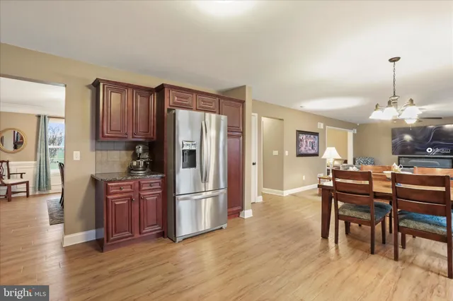a kitchen with stainless steel appliances granite countertop a refrigerator and a wooden cabinets