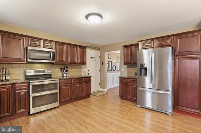 a kitchen with stainless steel appliances granite countertop a refrigerator stove and sink