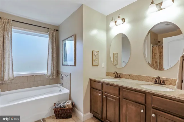 a bathroom with a double vanity sink double mirror and bathtub