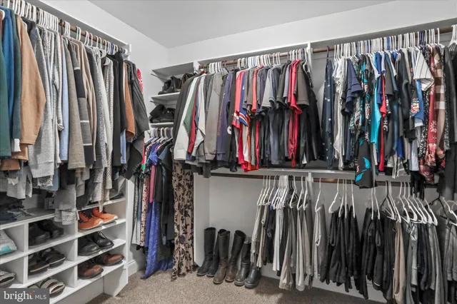 a view of walk in closet with clothes and shoes