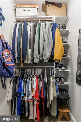 a view of walk in closet with clothes and shoes