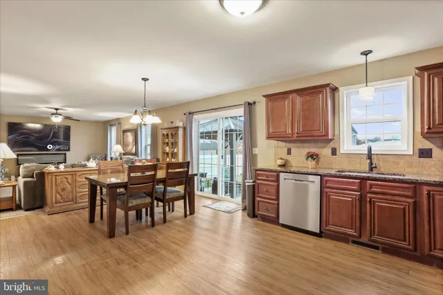 a open kitchen with stainless steel appliances granite countertop a stove and refrigerator a sink with wooden floors