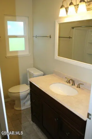 a bathroom with a sink a toilet and mirror