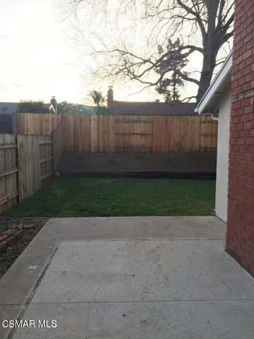 a view of a backyard with wooden fence