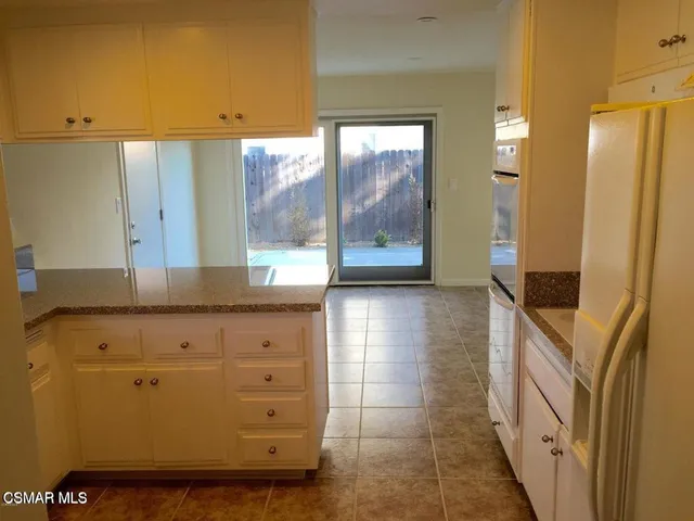 a view of hallway with granite countertop furniture and a large window
