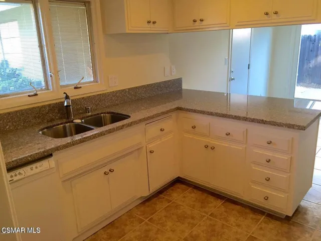 a kitchen with granite countertop white cabinets and sink