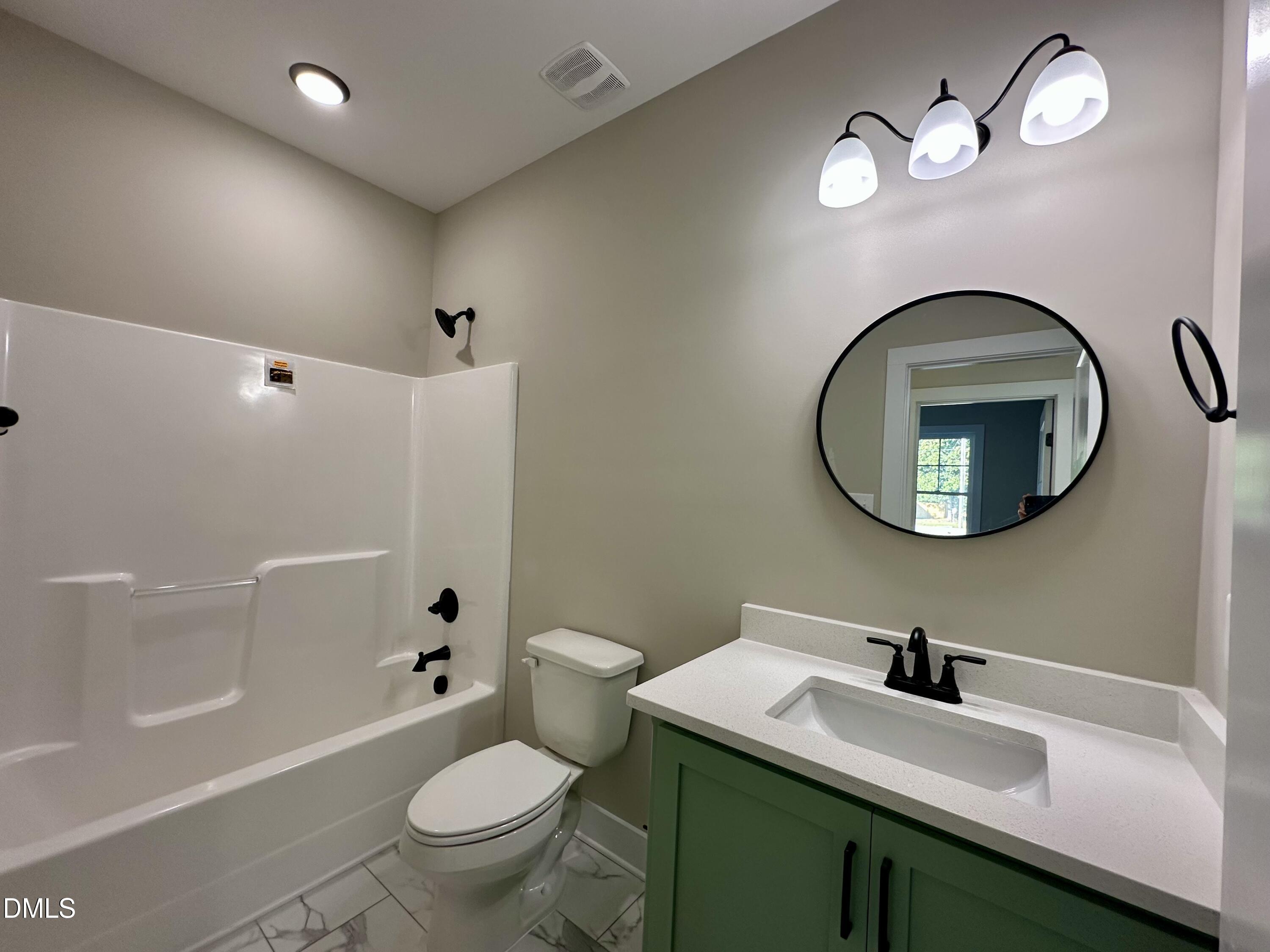 165 Bay Valley Road Kenly, NC 27542 - Photo 15 of 22 a bathroom with a toilet a sink and mirror