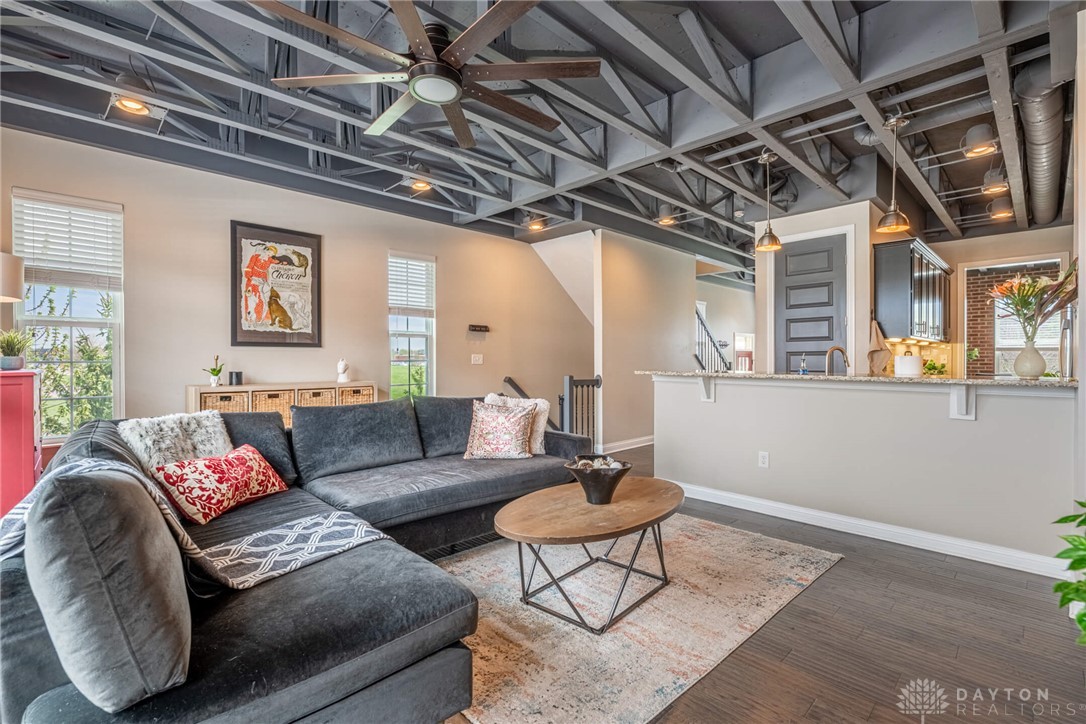 407 Brownstone Row Springboro, OH 45066 - Photo 13 of 54 This inviting space features an open concept, showcasing a modern industrial ceiling and rich wood flooring.