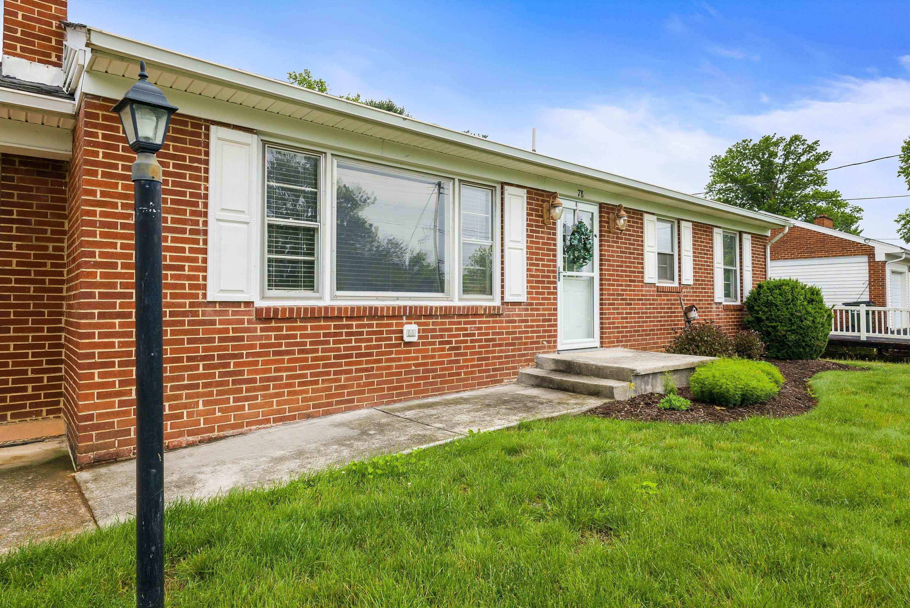 78 Stuart Avenue Stuarts Draft, VA 24477 - Photo 5 of 41 a front view of a house with a garden and yard