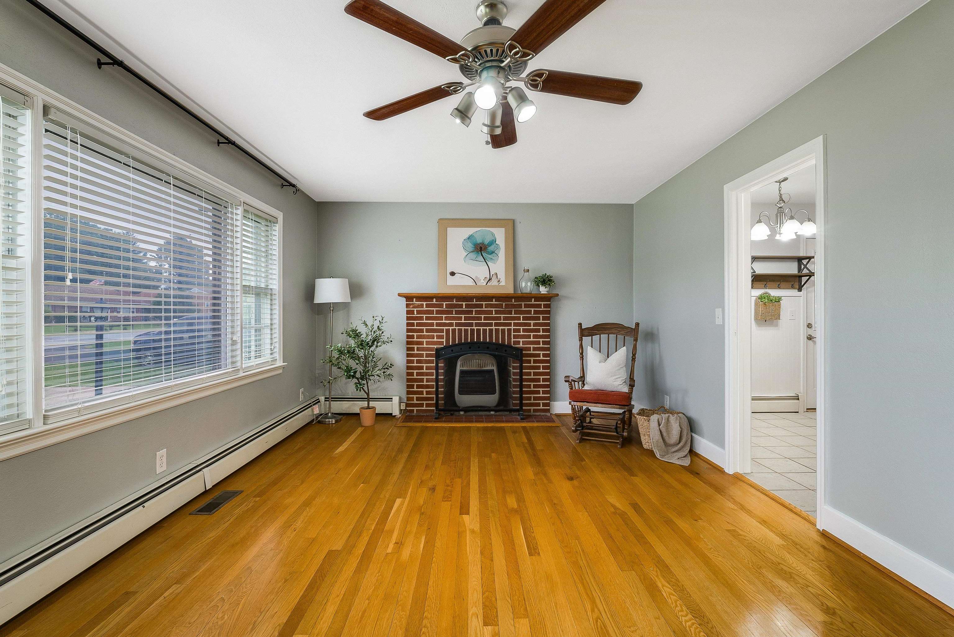 78 Stuart Avenue Stuarts Draft, VA 24477 - Photo 9 of 41 a view of a livingroom with a fireplace a ceiling fan and windows