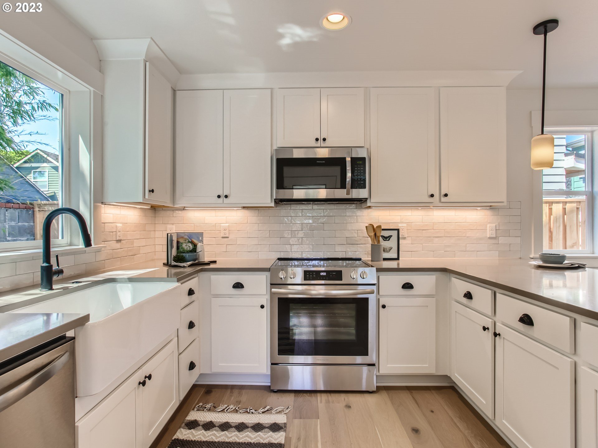 3134 North Winchell Street, Unit B Portland, OR 97217 - Photo 11 of 24 a kitchen with granite countertop a stove a sink and a microwave